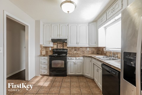 A kitchen with a black stove top oven and a black dishwasher.