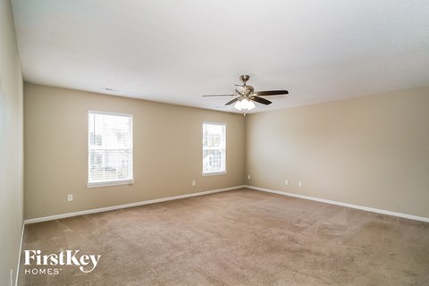 a living room with carpet and a ceiling fan