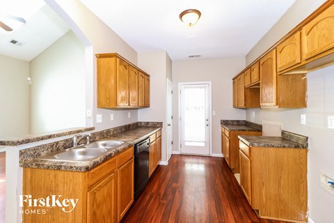 A kitchen with wooden cabinets and a marble countertop.