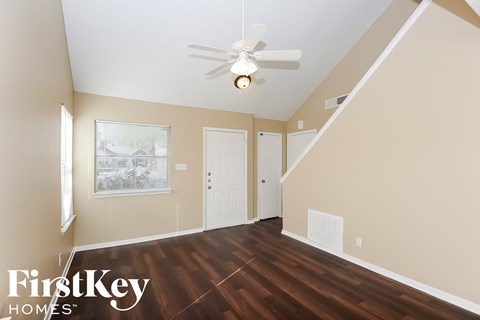 a living room with hardwood floors and a ceiling fan