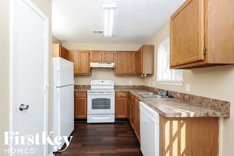 a kitchen with wooden cabinets and a white stove and refrigerator