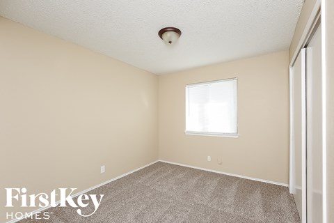 a bedroom with a carpeted floor and a window