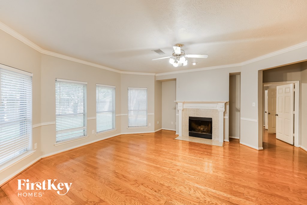 A spacious room with a fireplace and wooden floors.