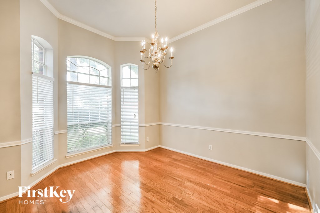A room with wooden floors and a chandelier.