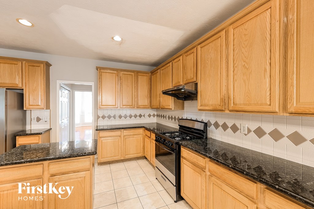 A kitchen with wooden cabinets and a black stove top oven.