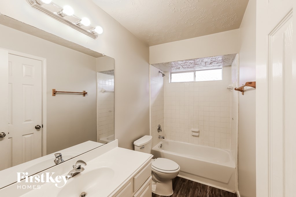 A white bathroom with a toilet, sink, and bathtub.