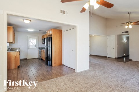 A spacious kitchen with wooden cabinets and a refrigerator.