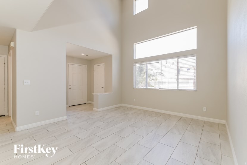 A spacious room with a large window and a door leading to another room.
