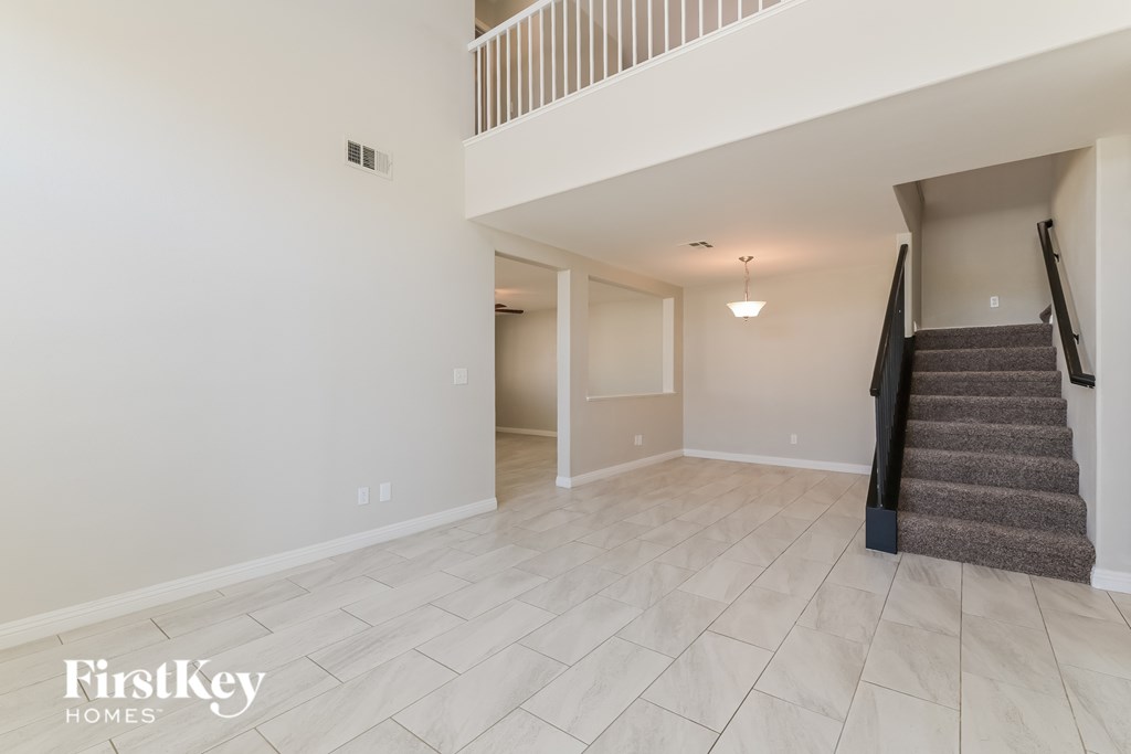 A spacious room with a staircase leading to another level.