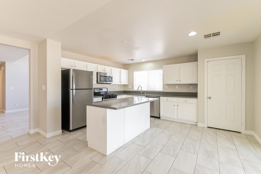 A kitchen with a refrigerator, microwave, and oven.