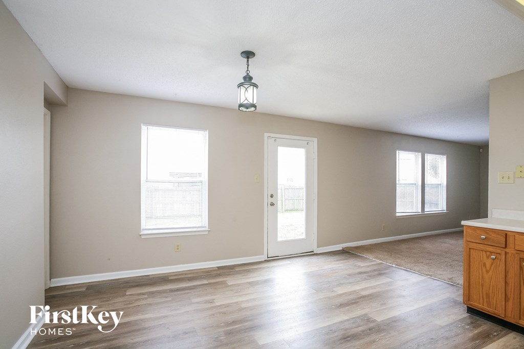 A room with wooden floors and a hanging light fixture.