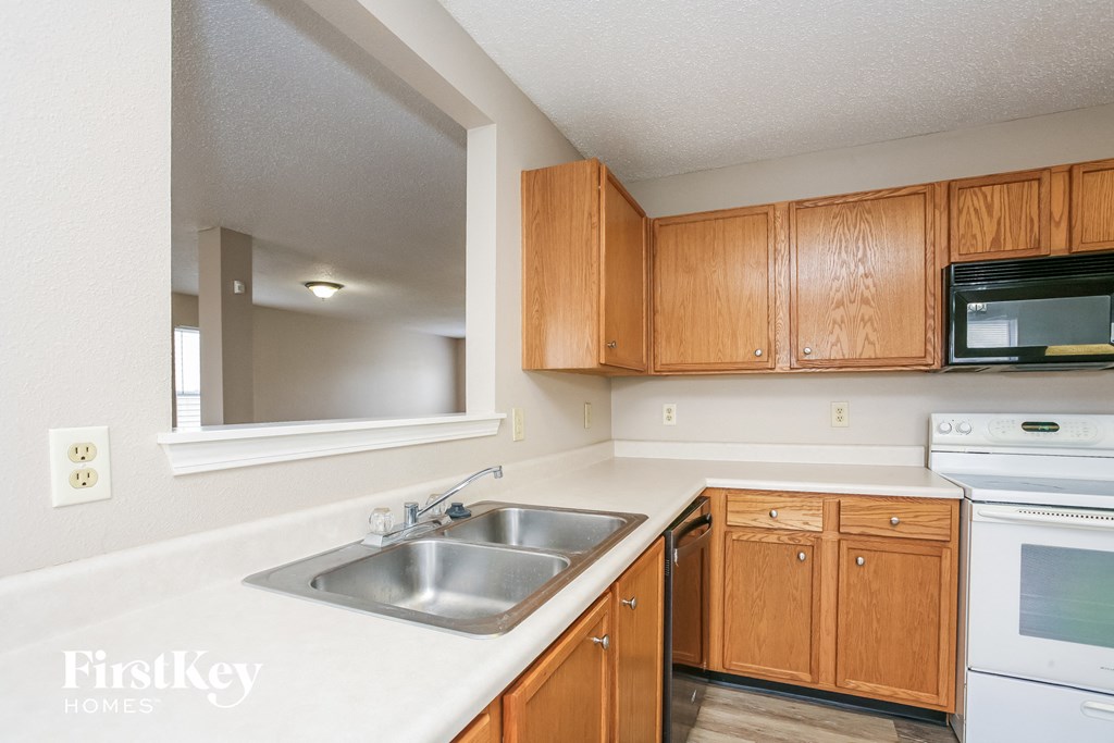A kitchen with wooden cabinets and a stainless steel sink.