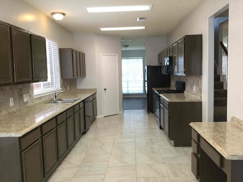 A kitchen with brown cabinets and a white door in the background.