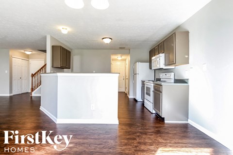 A kitchen with a white fridge and stove top oven.
