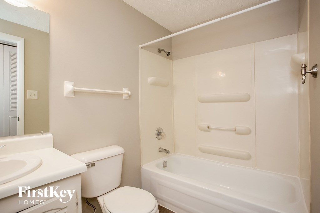 a white bathroom with a toilet and a tub and a sink