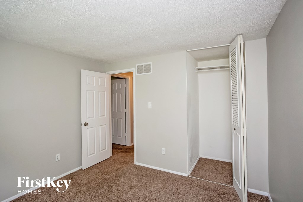 a bedroom with a closet and a door to a hallway