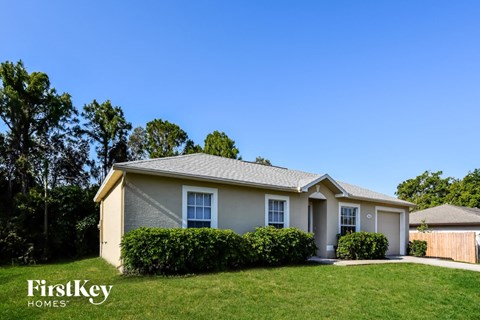 A house with a well-kept lawn and a clear blue sky above.