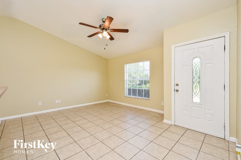 A room with a ceiling fan and a door leading to a balcony.