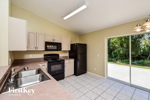 A kitchen with a sink, stove, and refrigerator.