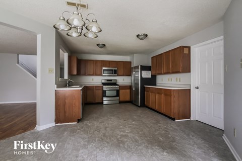 A kitchen with wooden cabinets and a refrigerator.
