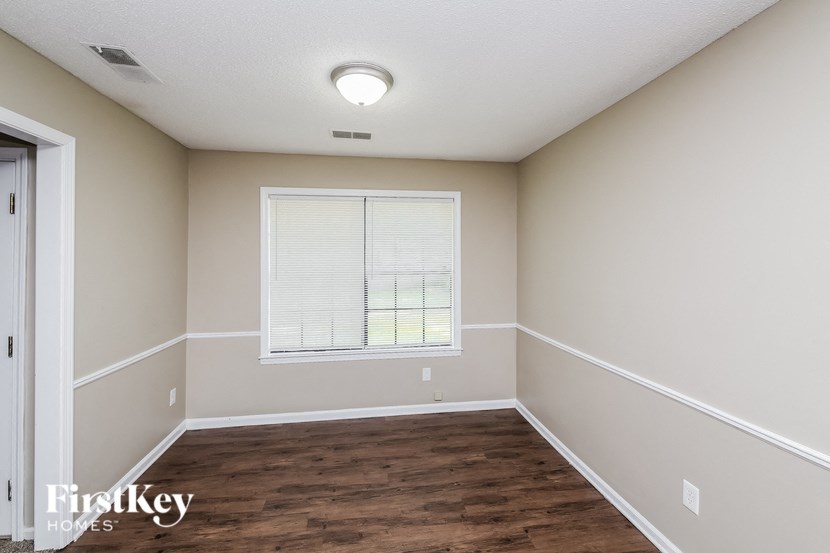 a empty room with wood flooring and a window