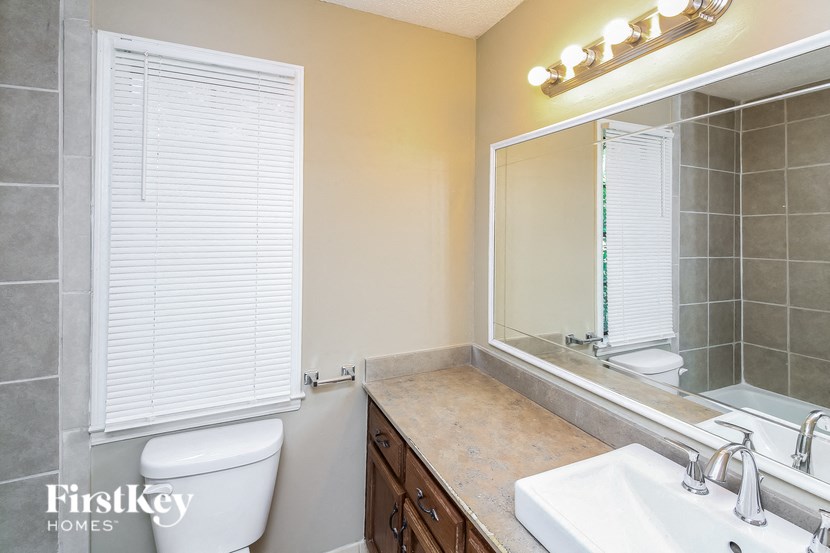 a bathroom with a sink toilet and a mirror