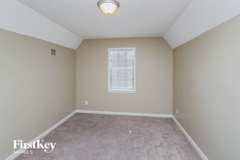 an empty room with beige walls and a window