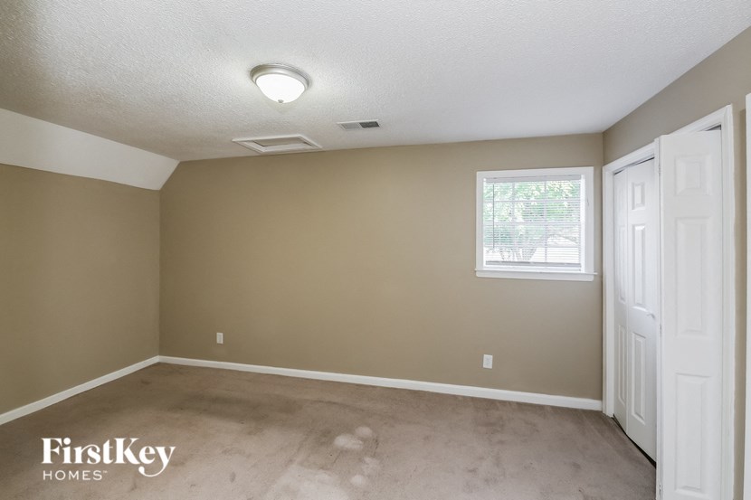 a empty living room with a white door and a window