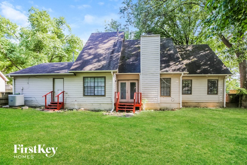 a white house with a black roof and a yard