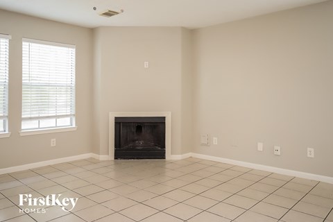 a living room with a fireplace and a tiled floor