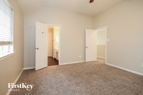 a bedroom with a carpeted floor and white doors