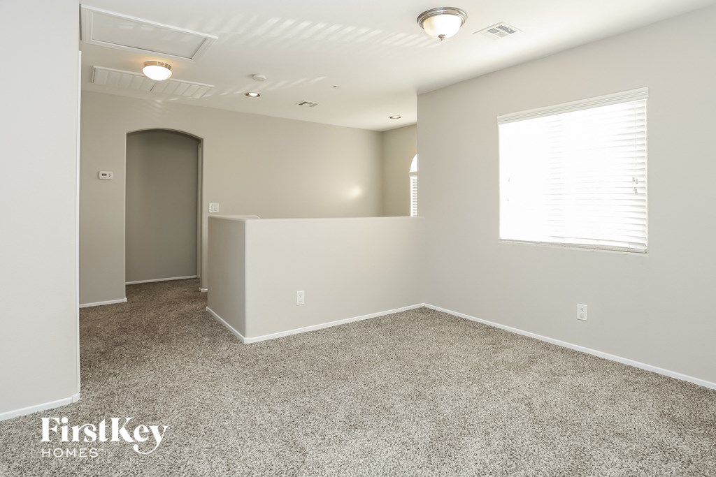 the upstairs bonus room has a large window and carpeted flooring