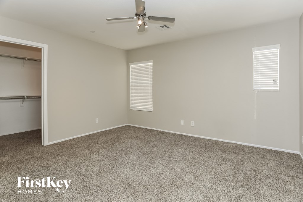 a room with carpet and a ceiling fan and a closet