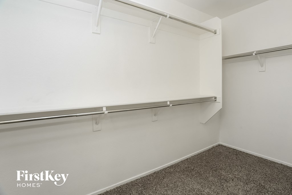 a hanging rail in a white wall in a room with a carpet