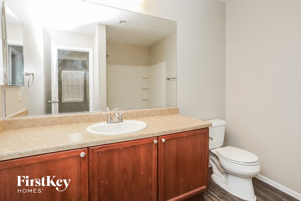 a bathroom with a sink toilet and a mirror