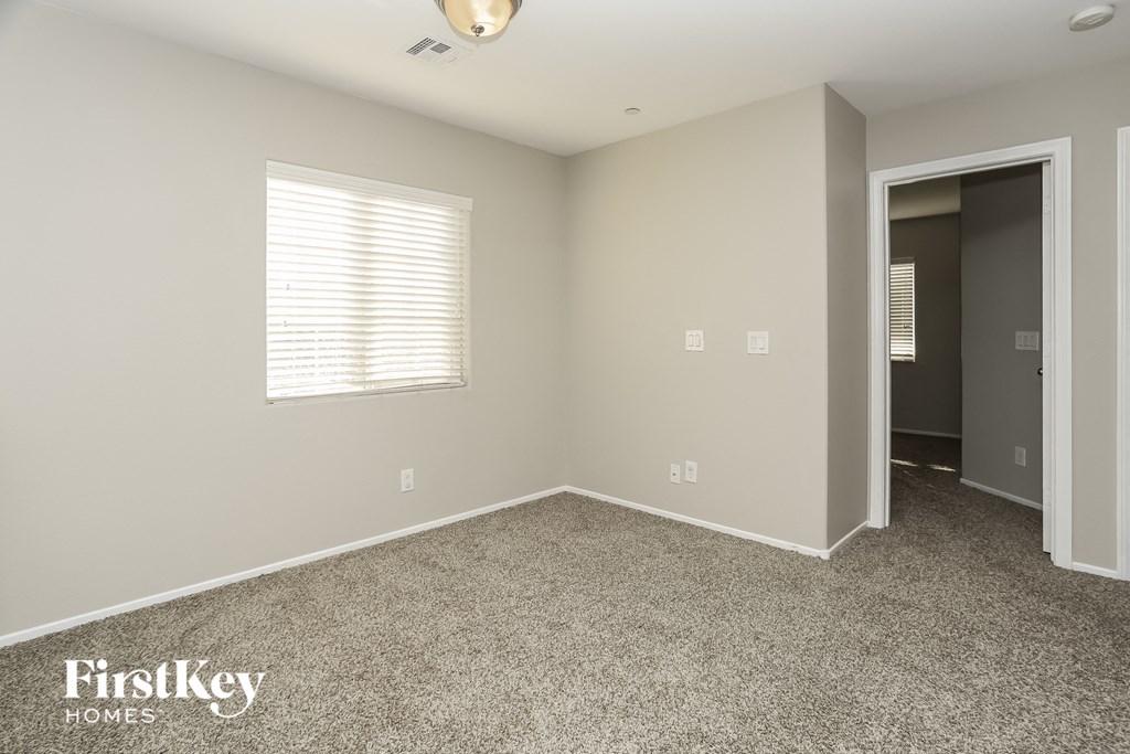 a bedroom with a carpeted floor and a door to a closet