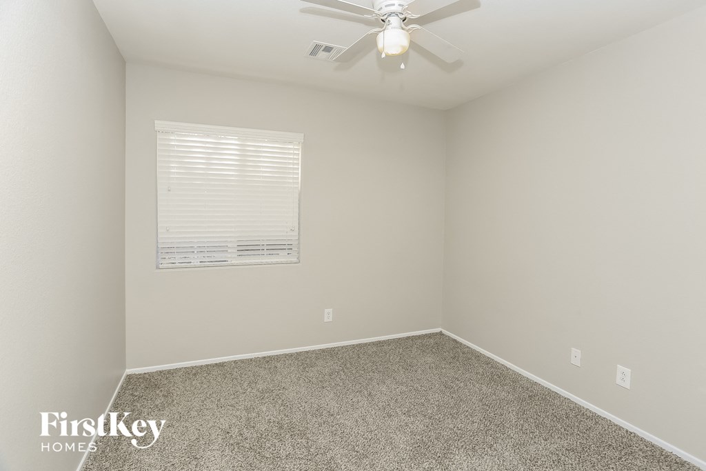 a bedroom with carpet and a ceiling fan