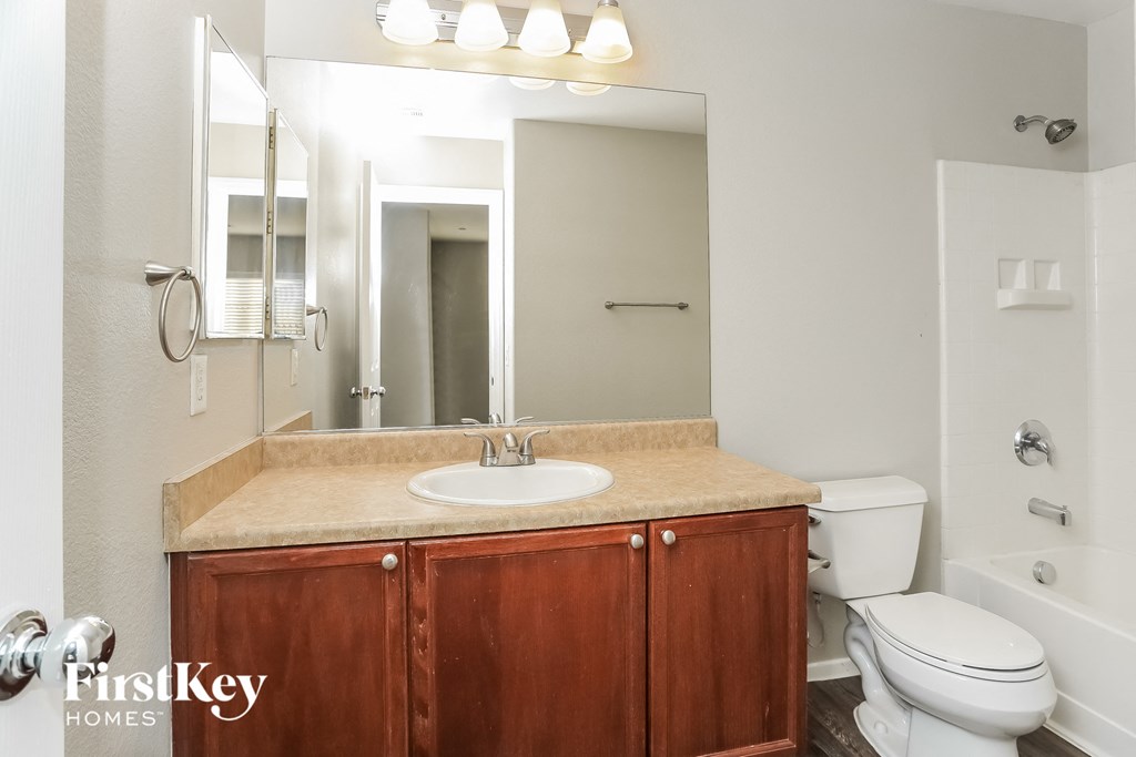 a bathroom with a sink toilet and a mirror