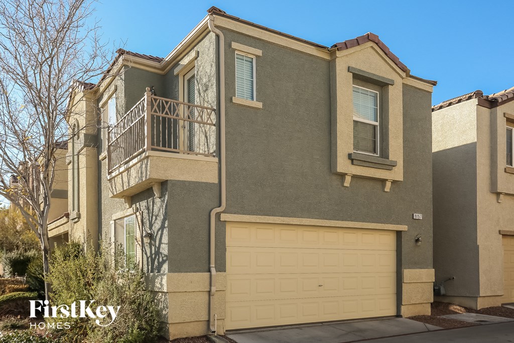 a house with a garage door and a balcony