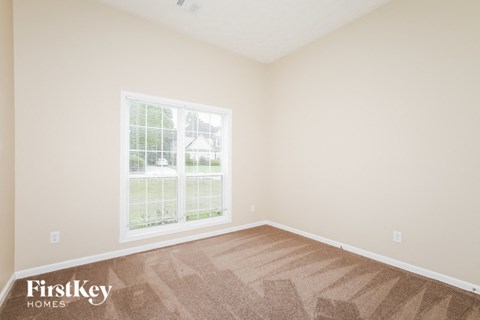 a bedroom with a large window and wooden floors