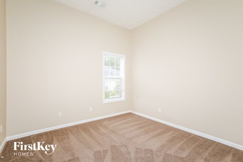 the living room of a home with a wooden floor and a window