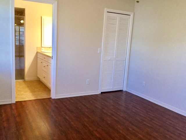 an empty living room with a closet and a bathroom