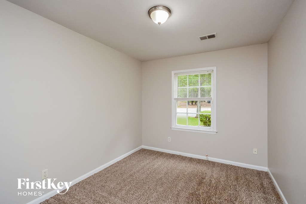 A room with a carpeted floor and a window.