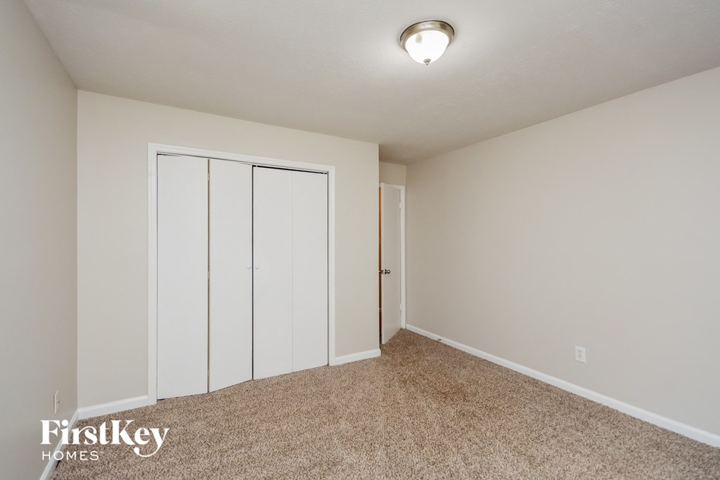 A room with a carpeted floor and a sliding door.