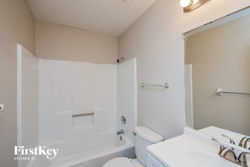 A white bathroom with a tub, toilet, and sink.