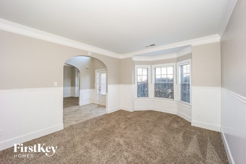 a living room with a carpet and a large window