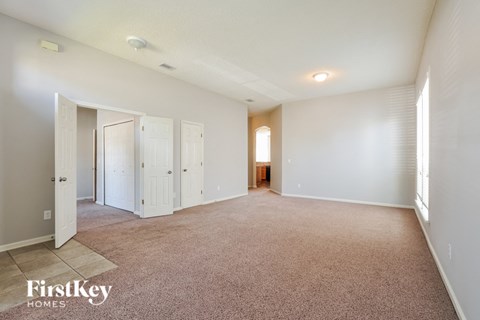 a spacious living room with carpet and white walls