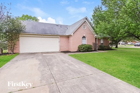 a brick house with a driveway and a white garage door