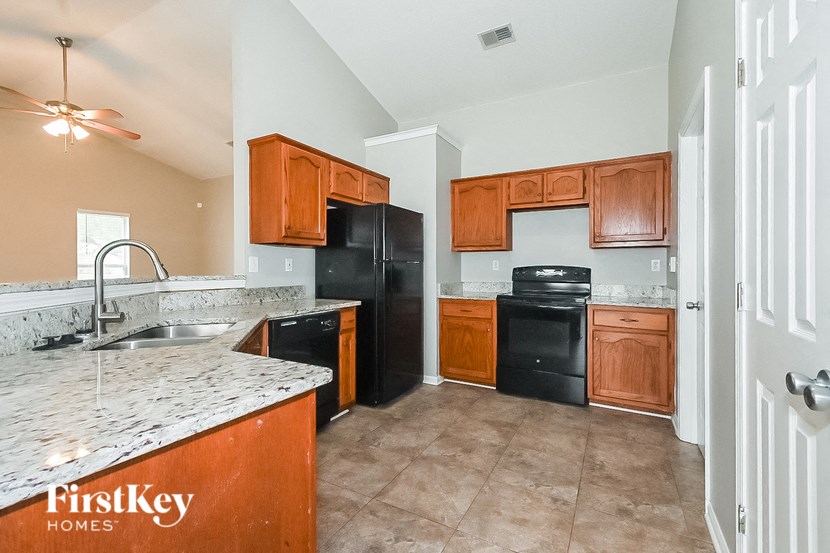 a kitchen with black appliances and marble counter tops