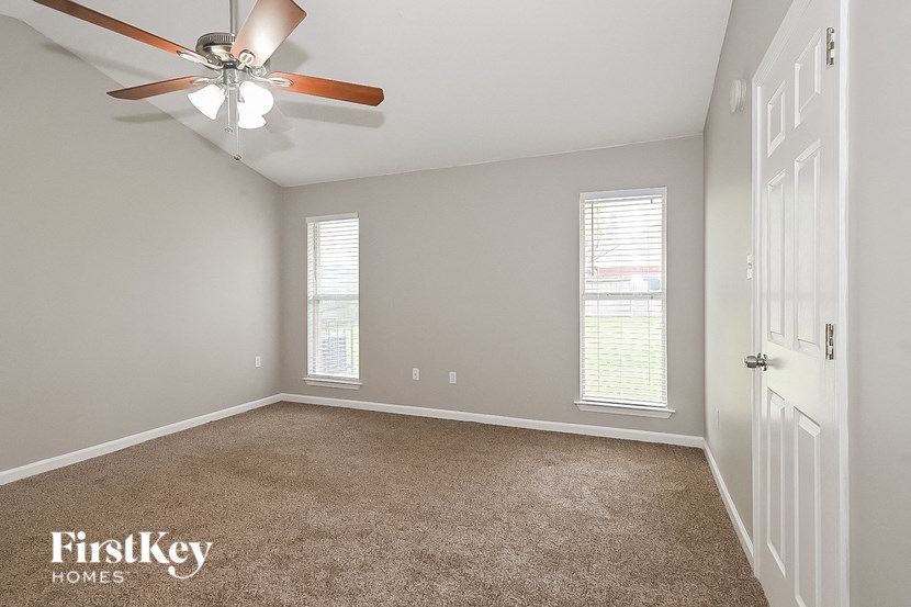 a bedroom with a ceiling fan and a white door